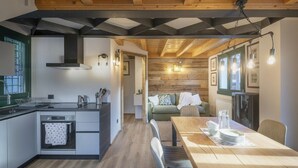 A modern kitchen with a central island, a dining area with a wooden table, and a cozy living space with a sofa.