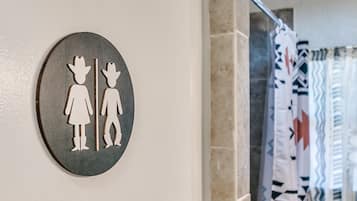 Ein rundes Schild mit zwei Personen, eine mit Hut und eine ohne, zur Kennzeichnung von WC für Damen und Herren.