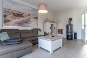 A modern living room with a sofa, a coffee table, a fireplace, and a large painting on the wall.