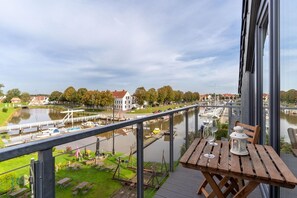 Ein Balkon mit Blick auf einen Fluss, Boote und Häuser.