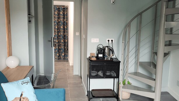 A hallway with a staircase, a coffee station, and a patterned curtain. - Our establishment is located not far from Clermont-Ferrand in the charming littl (Saint-Saturnin)