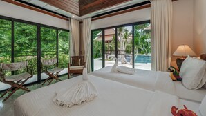 A hotel room with two beds, large windows, a ceiling fan, and a view of a swimming pool. - Naiharn 4br Private PoolVilla near Beach (Rawai)
