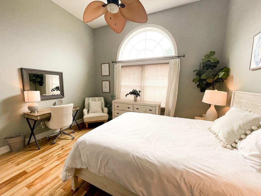 Downstairs Queen Room complete with desk space, sitting area, and ceiling fan.
