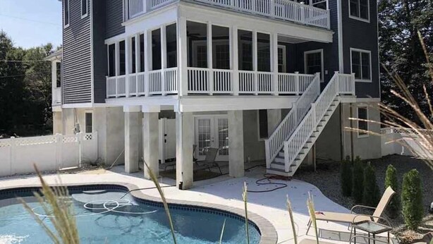 A two-story house with a balcony, a swimming pool, and a staircase leading to the upper level.