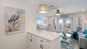 Una cocina moderna con armarios blancos, una isla grande y una zona de comedor con vistas.