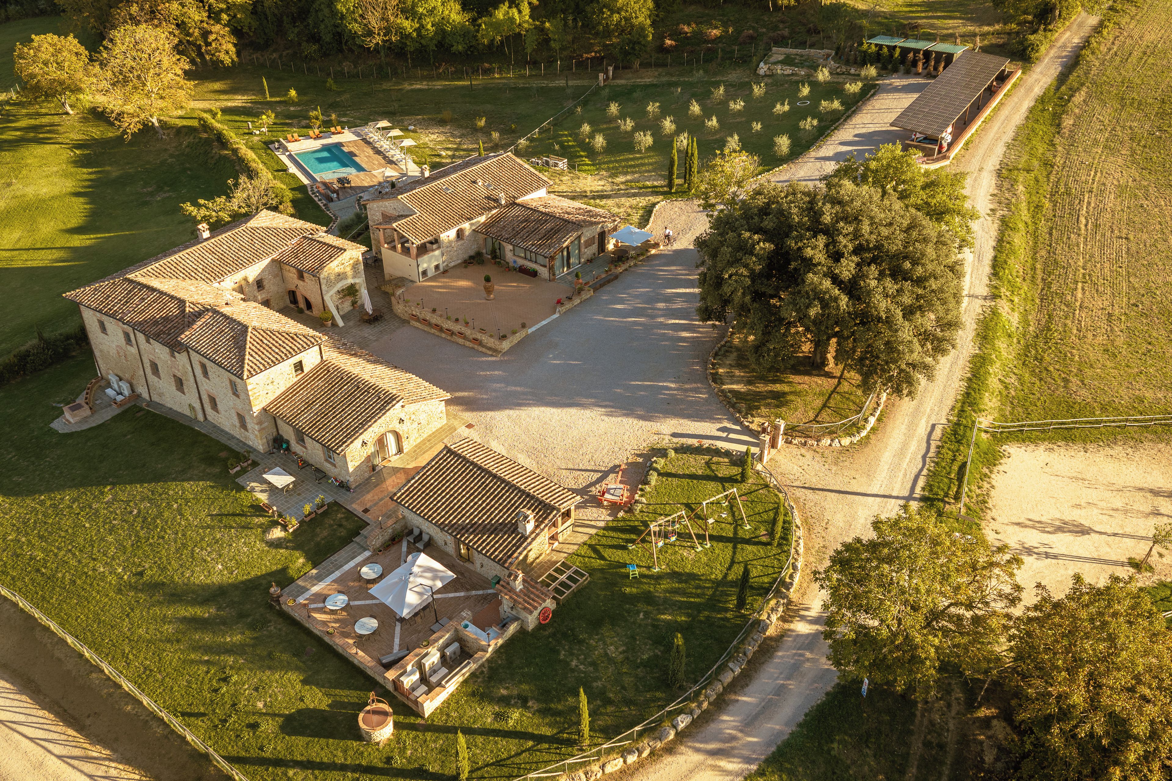 Un'ampia tenuta con diversi edifici, una piscina e un giardino curato.