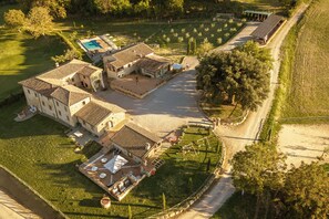 Un vaste domaine comprenant plusieurs bâtiments, une piscine et un jardin bien entretenu.