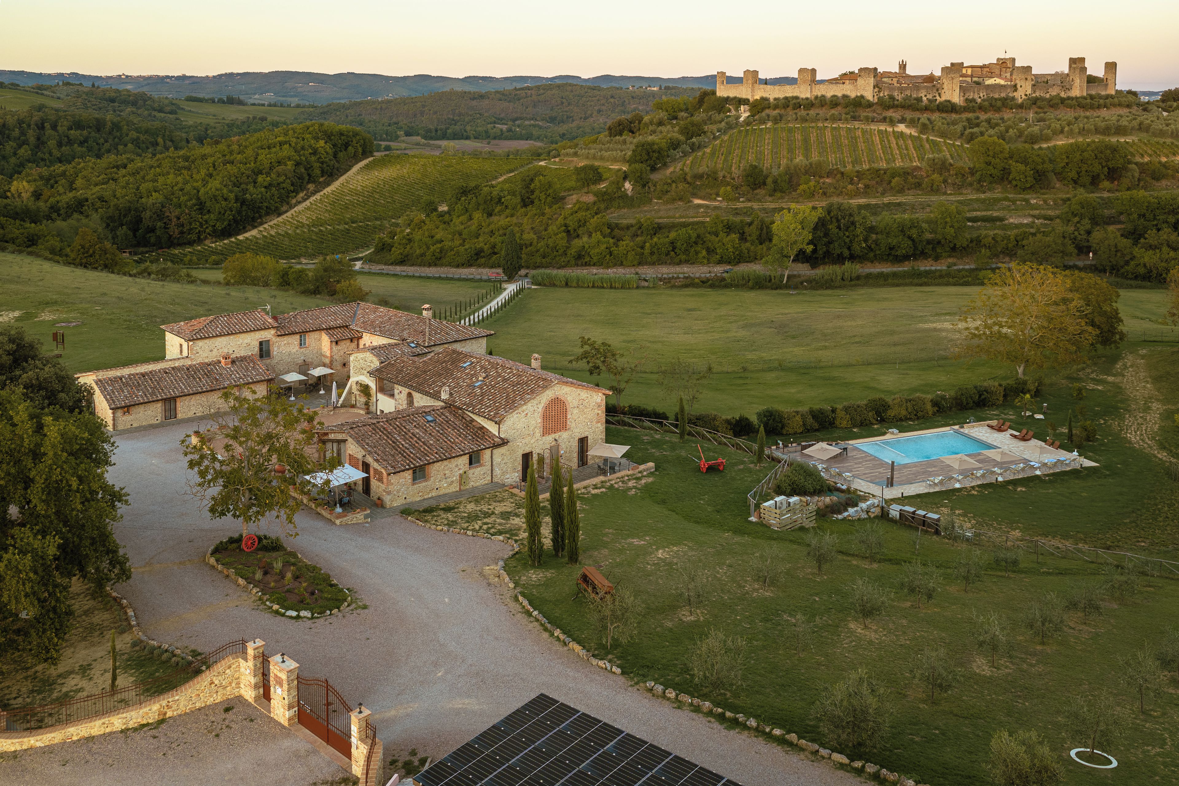 Une villa avec piscine, entourée d’un jardin bien entretenu et offrant une vue sur un château historique.