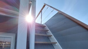 A staircase with wooden steps and a white handrail, leading to a landing with a view of the sky. - Houseboat Hecht with spacious roof terrace in Schleswig (Schleswig)