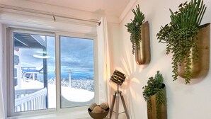 A room with a large window, a tripod lamp, and several wall-mounted planters. - Lux 1BR Ski IN/OUT: King+Queen, No Sleeper! @Lift (Snowshoe)