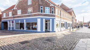 A historic building with a brick facade and a blue storefront. - 4 Person Holiday Home in Ringkobing (Ringkobing)