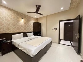 A modern bedroom with a large bed, a ceiling fan, and a wardrobe.