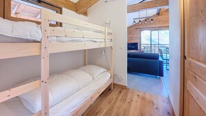 A bunk bed room with a wooden ceiling and a view of an outdoor seating area. - Snow Roc - 6/8 persons - Ski to door access - Mountain view (Saint-Jean-d´Aulps)