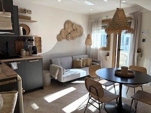 Een moderne keuken met een eethoek, een bank en een groot raam.