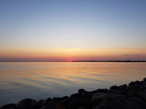 A calm body of water with a rocky shoreline in the foreground.