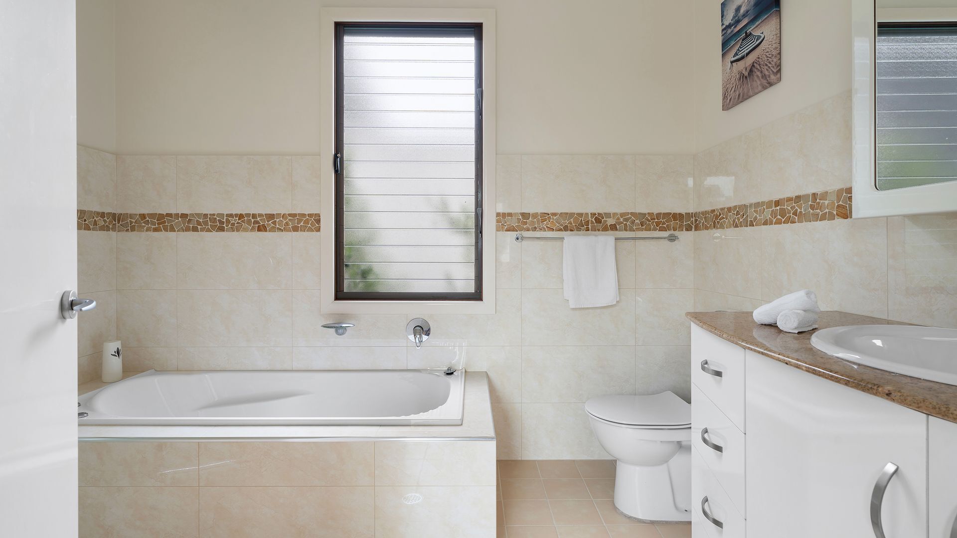 Et badeværelse med badekar, toilet og håndvask.