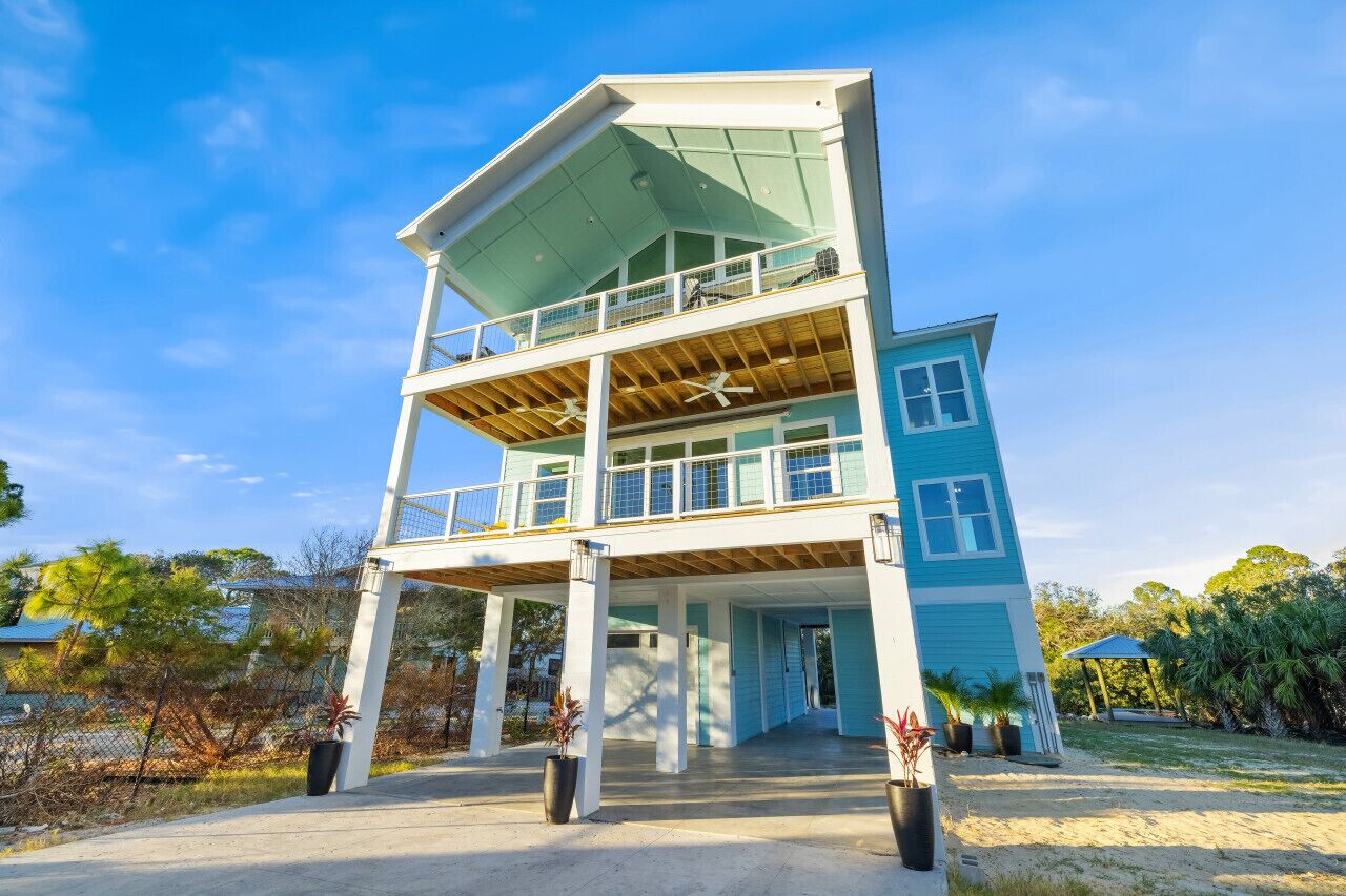 Un bâtiment à deux étages doté d’un balcon à l’étage supérieur, d’une entrée couverte et d’un jardin qui l’entoure.