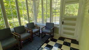 Una sala de estar con ventanales, suelo a cuadros y puerta al exterior.