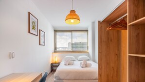 Ein modernes Schlafzimmer mit einem Bett, einem Nachttisch und einem Holzschrank.