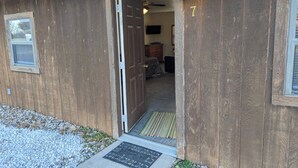 Een houten huis met een deur die naar een binnenruimte leidt.