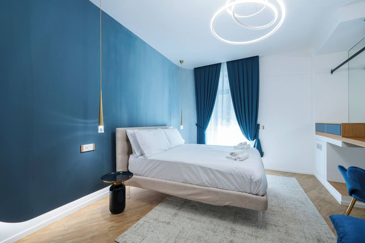 A modern bedroom with a bed, a desk, and a chair.