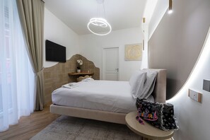 Une chambre d’hôtel moderne avec un grand lit, une table de chevet, un téléviseur fixé au mur et un élément décoratif mural.