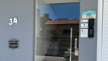Una entrada de edificio con puerta de cristal, buzón y el número 34 en la pared.