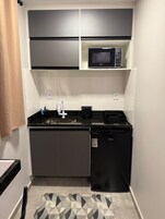 Una cocina compacta con microondas, lavavajillas y una pequeña encimera.