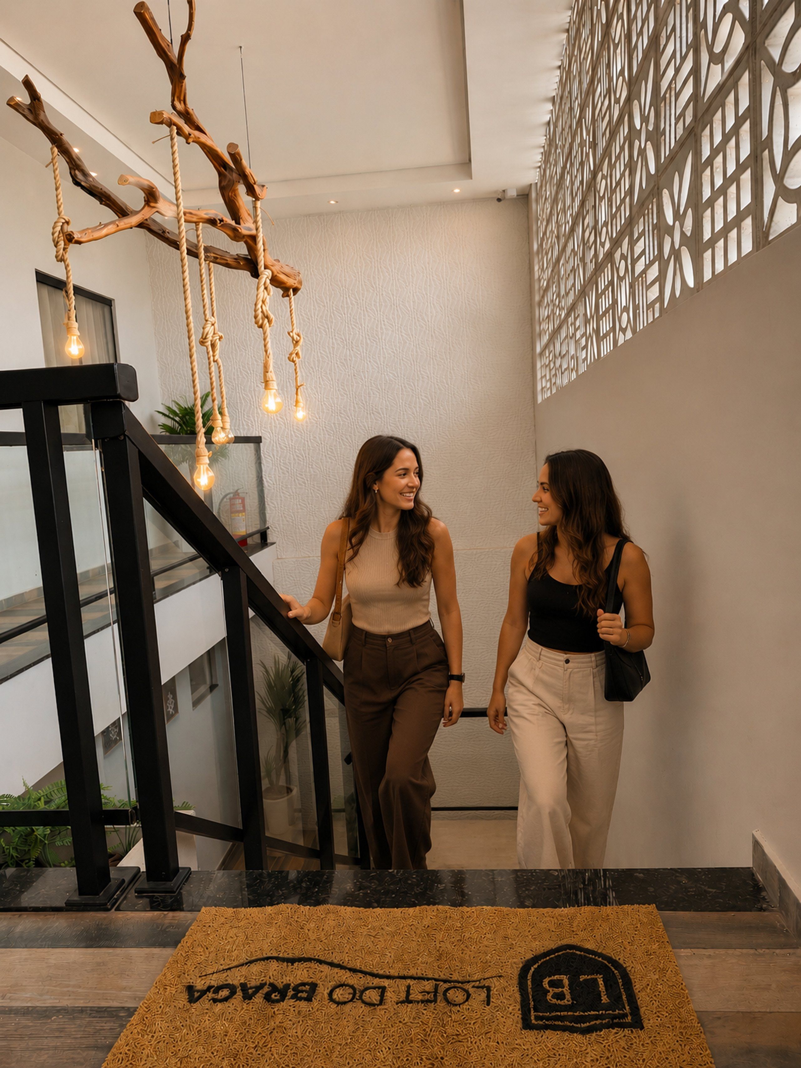 Two individuals walking on a staircase with a modern interior design, including a textured wall and a decorative light fixture.