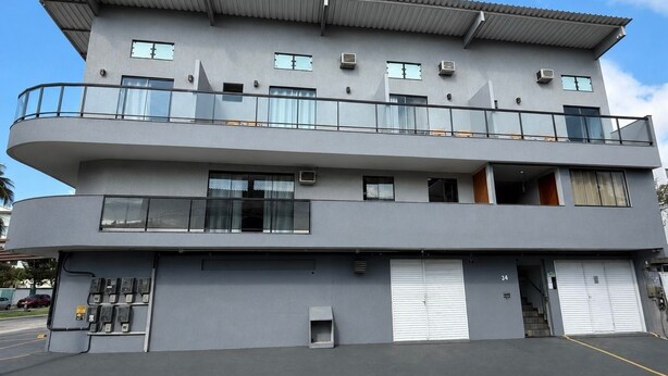 Un immeuble à plusieurs étages, doté de balcons, de grandes fenêtres et d’un toit plat.
