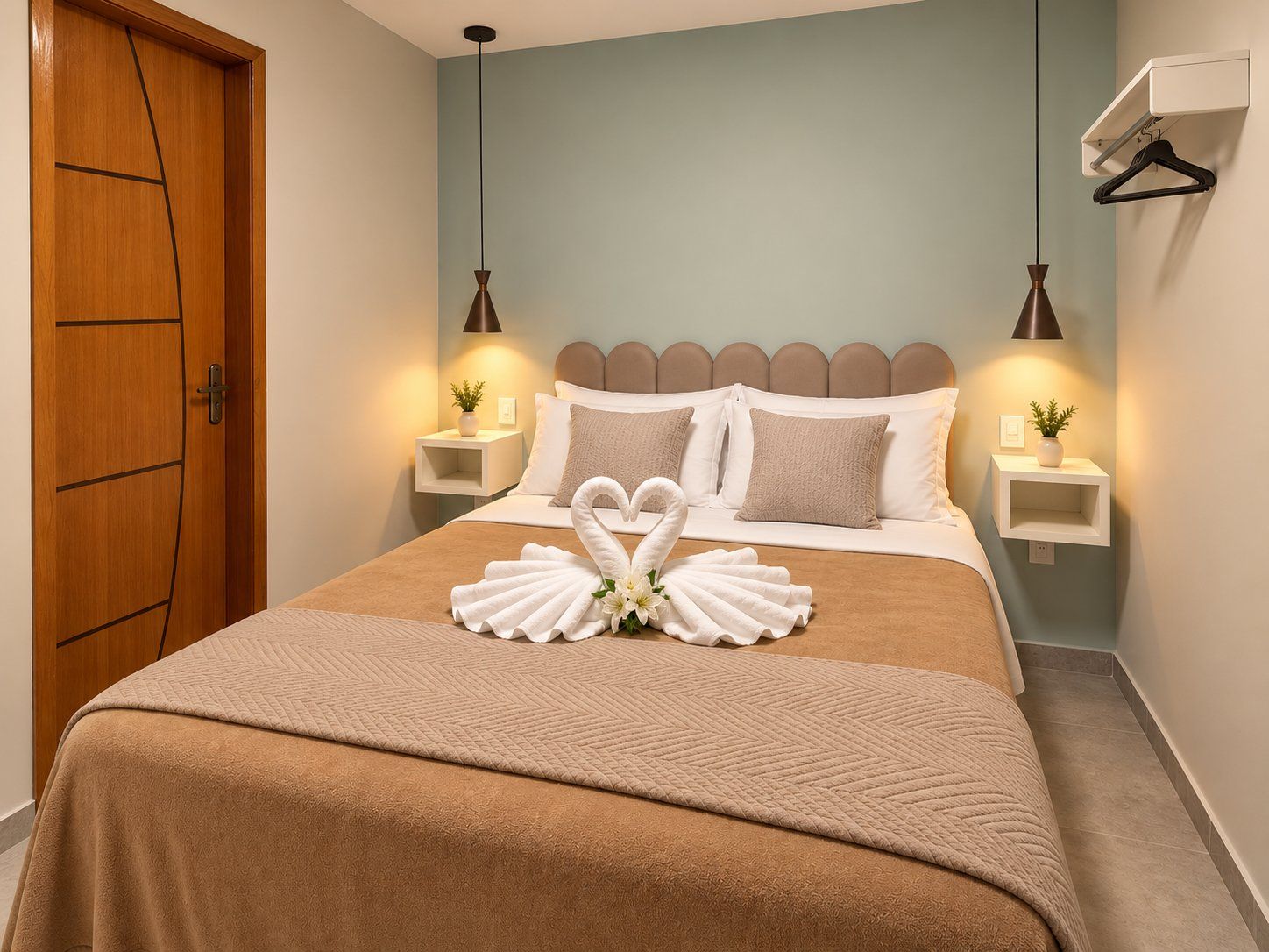 Una habitación de hotel con cama, mesitas de noche, lámparas y una decoración de toallas.