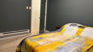 A bedroom with a bed, a door, and a small table. - 1st fl 2-bedroom apartment with WiFi, AC in fantastic Philadelphia (Philadelphia)