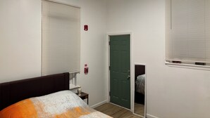 A bedroom with a bed, a green door, and a window with blinds. - 1st fl 2-bedroom apartment with WiFi, AC in fantastic Philadelphia (Philadelphia)