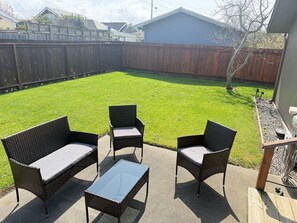 A backyard patio with wicker furniture and a table. - Quiet 2BR • Garage • Yard • EV Charger – Eureka (Eureka)