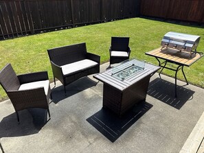 An outdoor patio with wicker furniture, a glass-top table, and a barbecue grill. - Quiet 2BR • Garage • Yard • EV Charger – Eureka (Eureka)