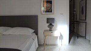 A bedroom with a bed, bedside table with a lamp, and a framed picture on the wall. - Centromare Trapani (Trapani)