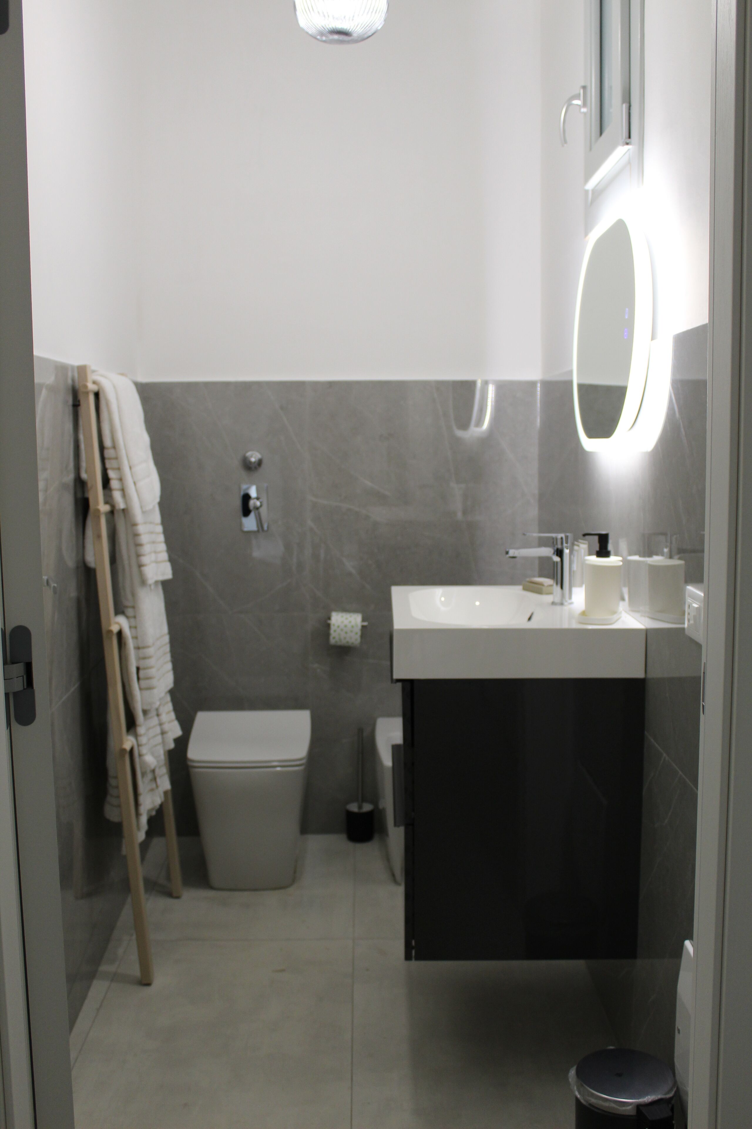Une salle de bain moderne équipée de toilettes, d’un lavabo et d’un miroir.