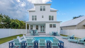 A two-story house with a swimming pool and outdoor seating. - NEW - Symphony! Sleeps 18! Pool! Golf Cart (Santa Rosa Beach)