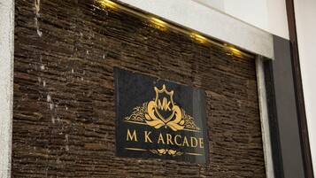 Un letrero con el texto 'MK Arcade' sobre una pared con textura.