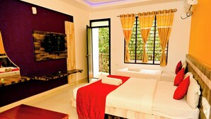 Une chambre d’hôtel avec un lit, une télévision, un bureau et une fenêtre avec des rideaux.