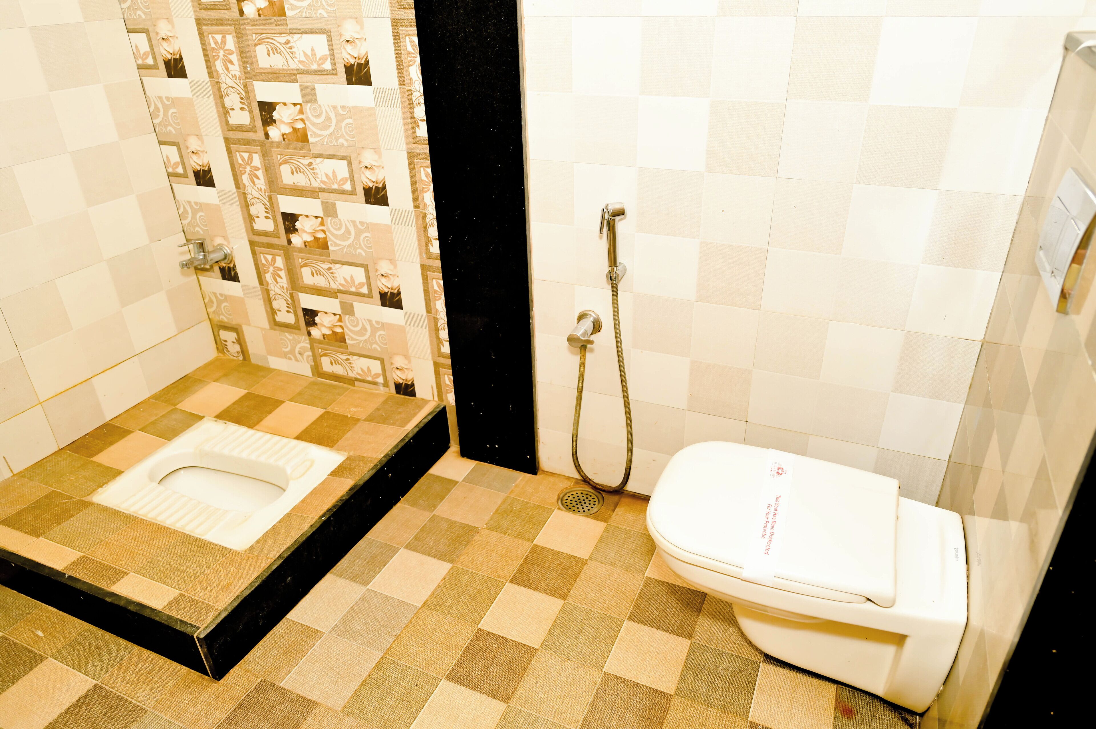 A bathroom with a toilet, shower, and a checkered floor.