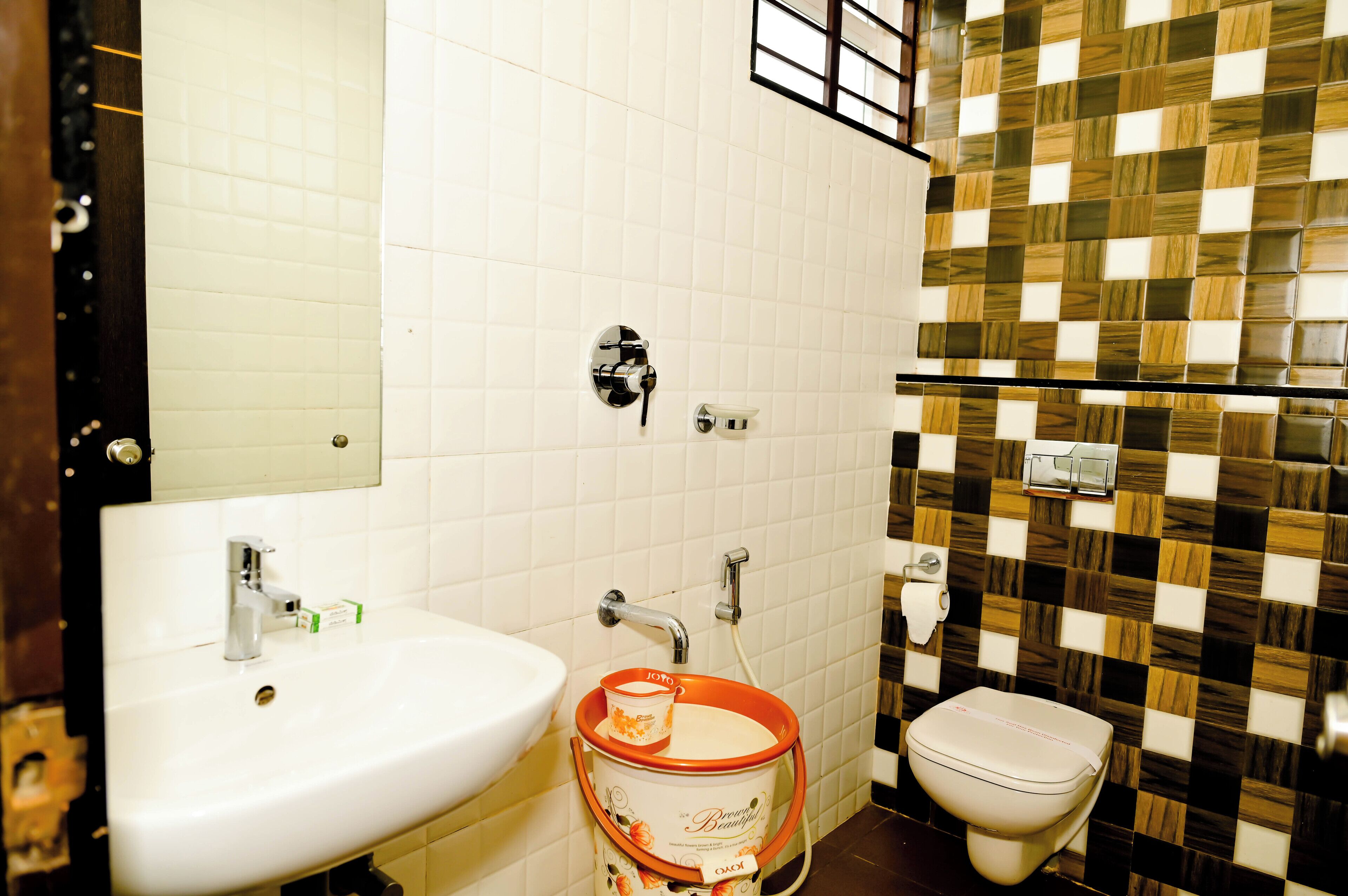 A bathroom with a white sink, a toilet, and a mirror.