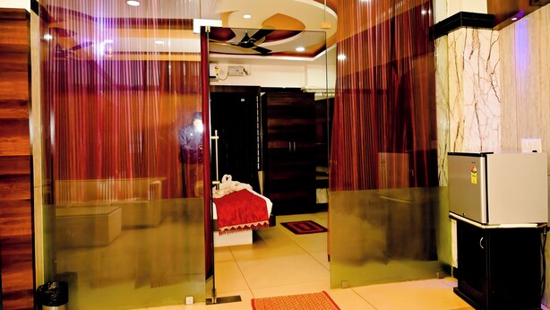 Une chambre d’hôtel équipée d’un lit, d’un réfrigérateur et d’un ventilateur de plafond.