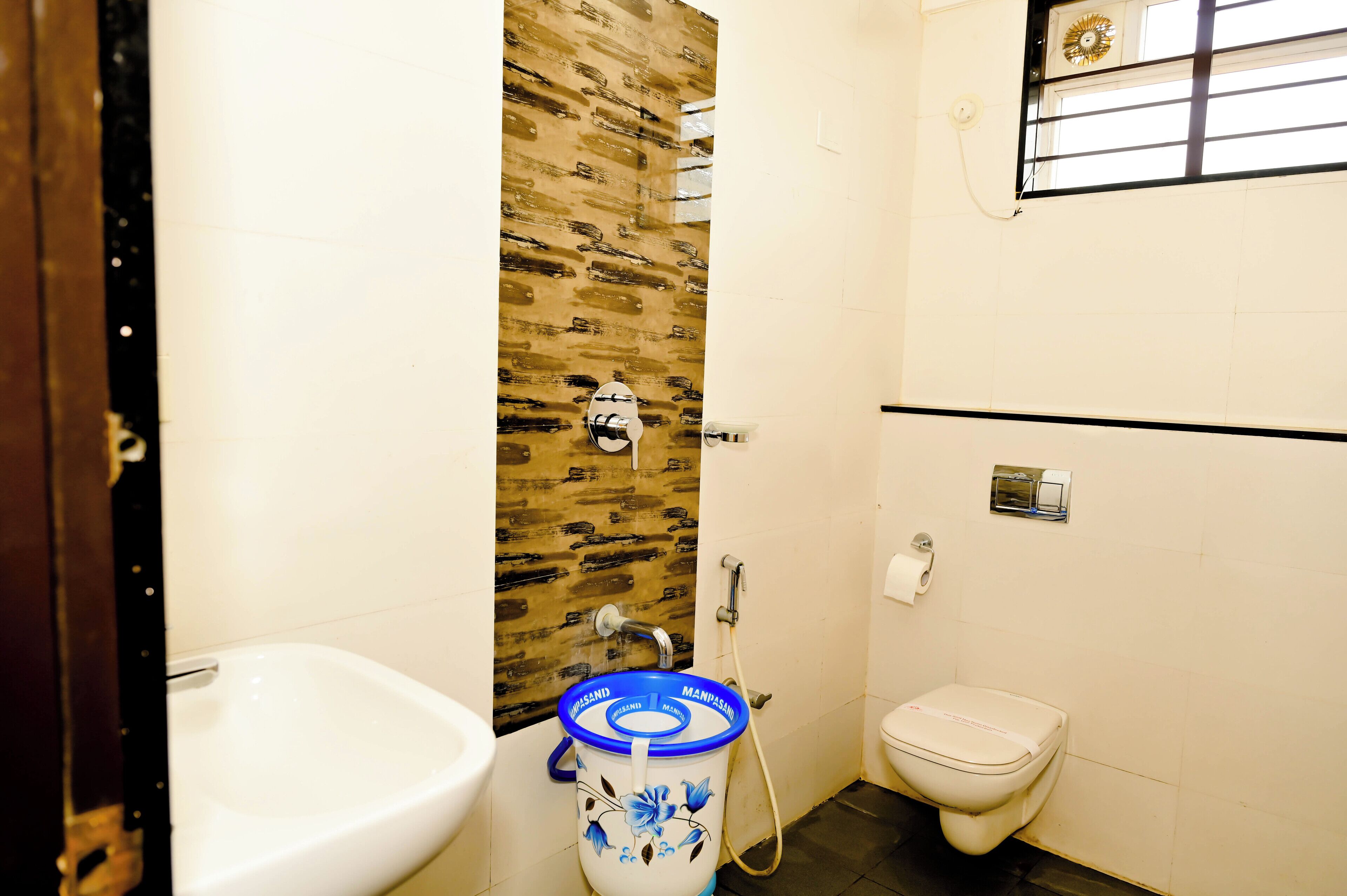 A small bathroom with a white sink, a toilet, and a blue water dispenser.