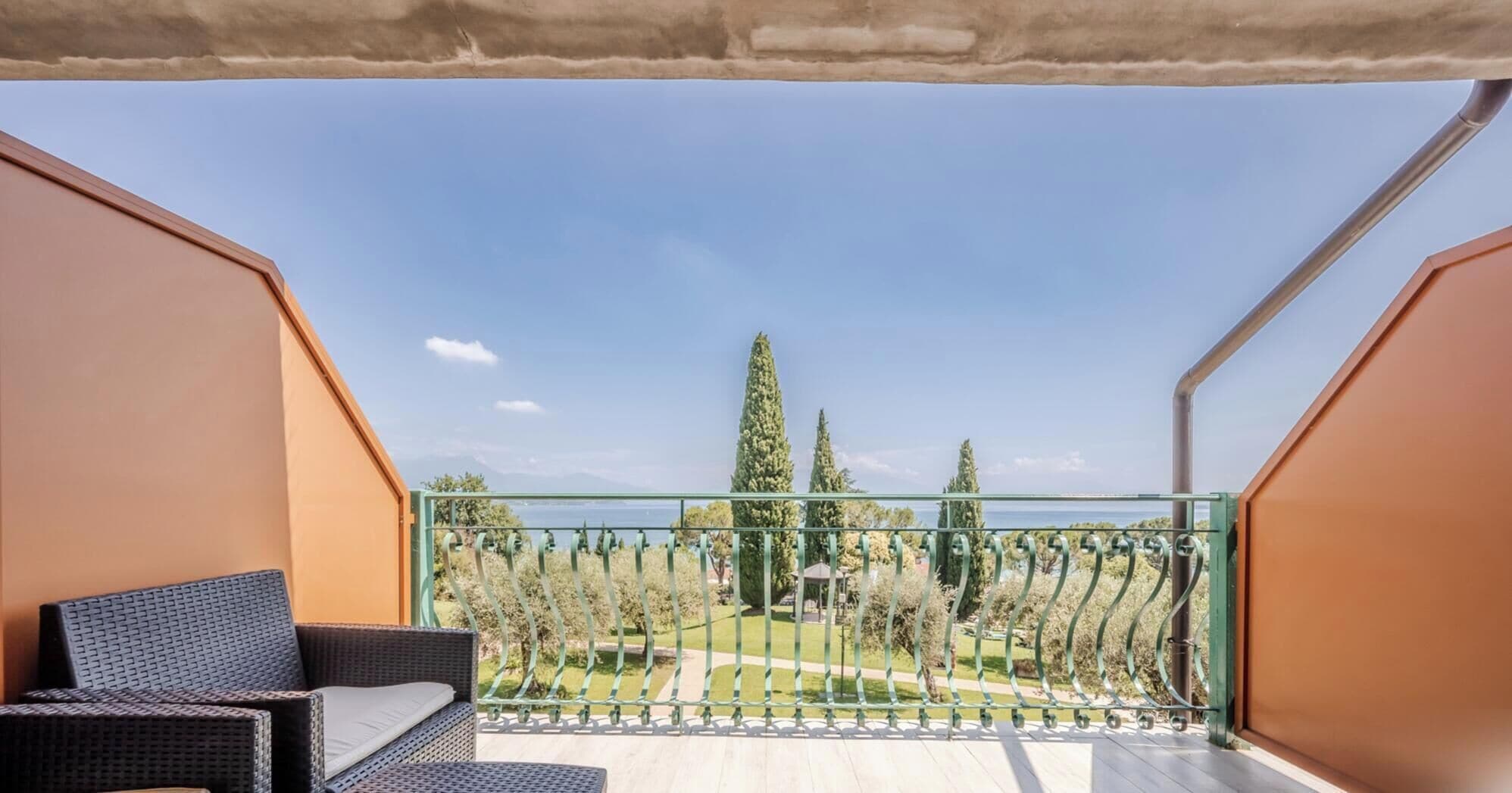 Un balcone con vista su un parco e alberi.