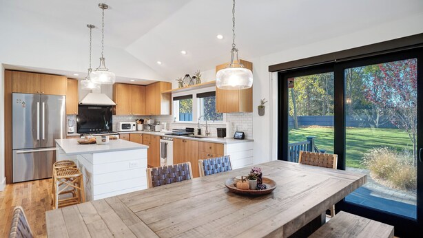 A modern kitchen with a central island, stainless steel appliances, and a large dining table with chairs. - Spacious and Modern North Fork Home Close to Multiple Wineries, Perfect for... (Cutchogue)