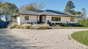 A single-story house with a gravel driveway and a well-maintained lawn. - Spacious and Modern North Fork Home Close to Multiple Wineries, Perfect for... (Cutchogue)