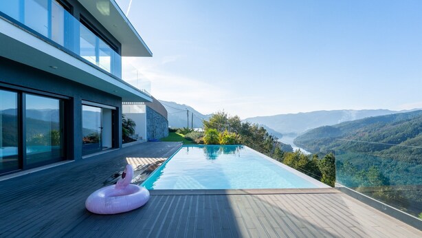 A modern house with a large pool and a view of the mountains.