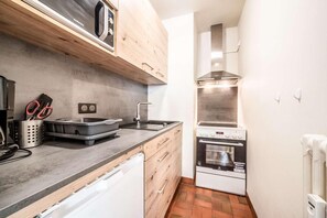 A compact kitchen with a microwave, oven, and sink. - 50m from ski slopes, 2nd floor, balcony, tv, 27m², Morzine (Morzine)