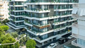 Un edificio de varios pisos con balcones, ventanas amplias y techo plano.